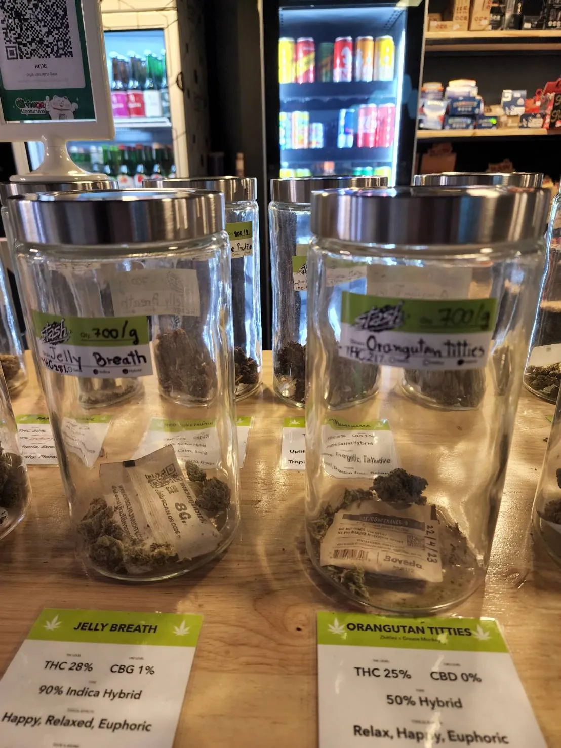 Cannabis flower jars with strain labels on display at Stash BKK Bangkok
