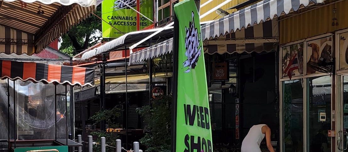 Stash BKK On Nut early days — green Weed Shop banner and storefront